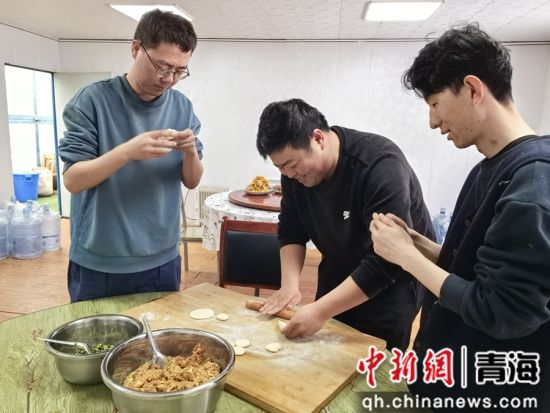 图为电网工作人员在项目部包饺子。王元明摄