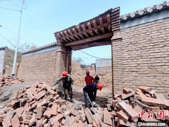 图为建筑队伍帮助受灾民众重建房屋。李隽 摄