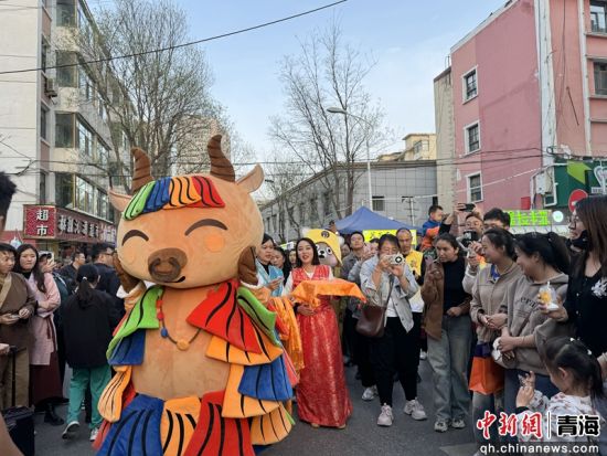 图为卡通人偶跟游客互动。祁绣娟 摄