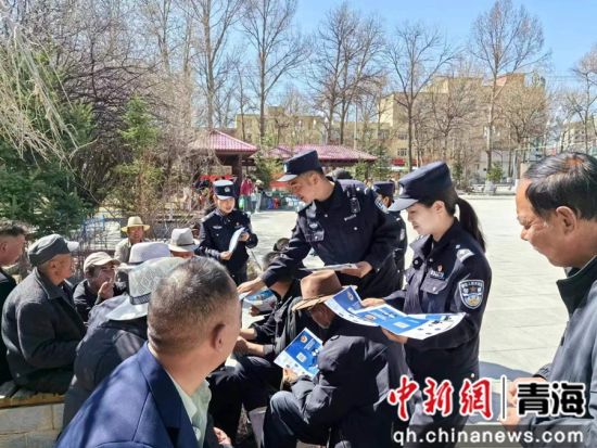 图为民警向居民发放宣传单，普及反诈小常识。兴宣供图