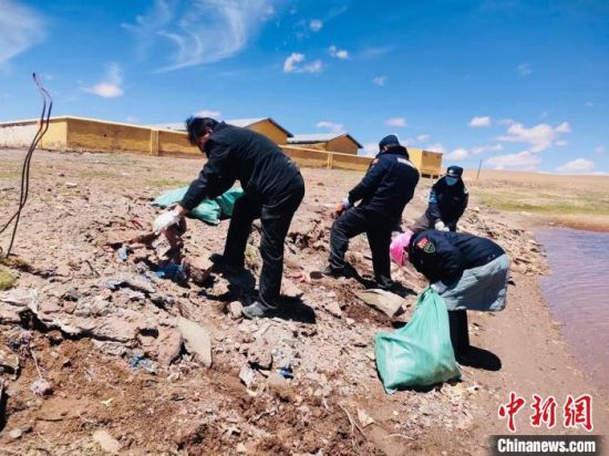 图为长江源村生态管护员巡护时捡拾垃圾。 　　青海省海西州格尔木市委组织部供图