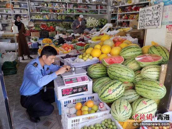 图为湟中区市场监督管理局执法人员对瓜果蔬菜店的电子计价秤进行计量检定。马薇茹供图