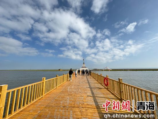 图为仙女湾景区内，游客在木栈桥上观赏青海湖湖面风光。潘雨洁 摄