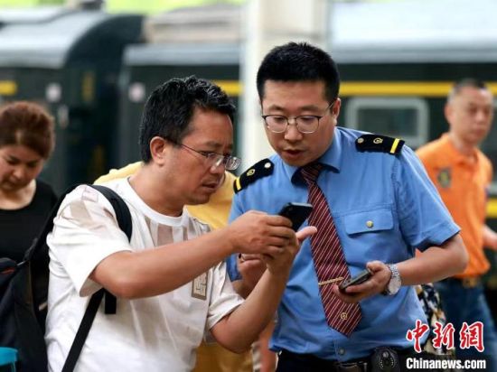 资料图为旅客向乘务人员咨询相关情况。青藏集团公司供图