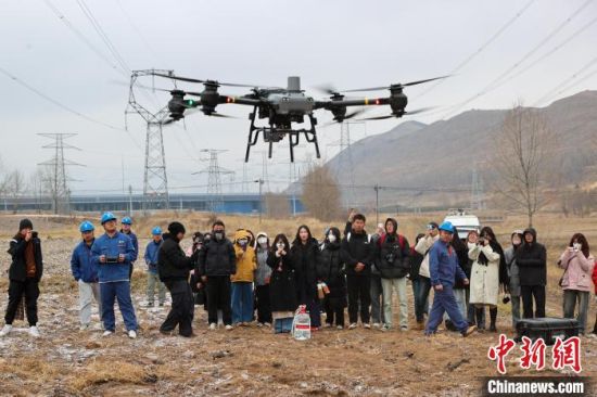 图为大学生观看电力检修工作人员展示的运载无人机。薛蒂 摄