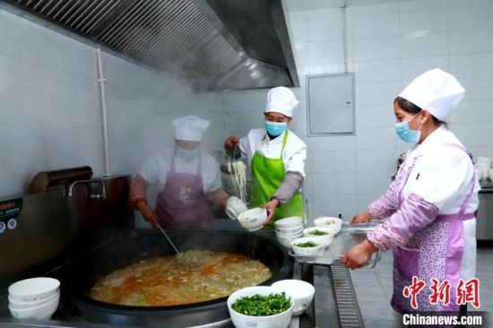 图为金田村幸福食堂饭菜出锅。石延寿 摄